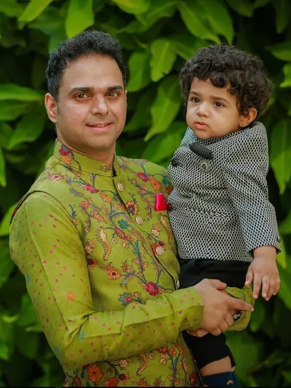 Creating picture-perfect moments for fathers and sons. Here, a happy client’s son wears our custom-tailored jacket, a modern design that perfectly complements his dad's style for a family wedding.
