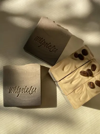 A closer look at the custom coffee soaps created for a wedding. The ombré design mirrors a sunset, while the other is topped with real coffee beans.