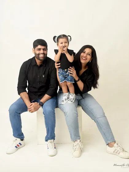 A playful and happy family photo. The little girl's joyful expression is the centerpiece of this fun and casual portrait with her parents.