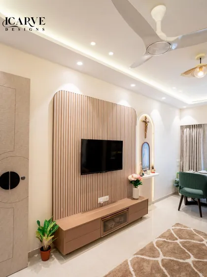 A view of the TV and altar area, showcasing the fluted wood paneling and the custom-lit niche for religious idols.