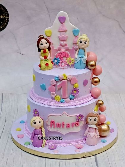 This two-tier blueberry cake is a royal fairytale for a first birthday. It features fondant figures of beloved princesses, a castle silhouette, and soft pastel colors for a truly enchanting look.