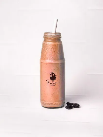A bottled oats and raisin shake from 'Protein Bowls', shot against a clean white tiled background. This is a straightforward product shot, perfect for a fitness or health brand's menu.