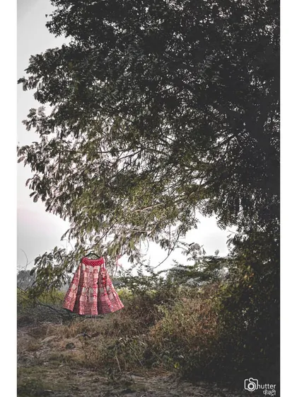 The bridal lehenga, hung in a natural setting. This artistic shot turns the wedding dress into a beautiful portrait of its own.