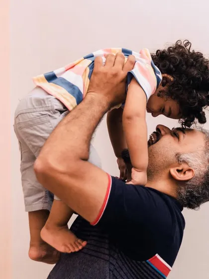 A different perspective of a father lifting his son, showing the pure joy and connection from another angle. These are the real, unposed moments that truly define your family's story.