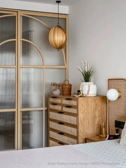 This bedroom showcases a Japandi-inspired aesthetic, blending natural wood, rattan, and fluted glass. It’s a perfect example of how I create calm, uncluttered sanctuaries that are full of texture and warmth.