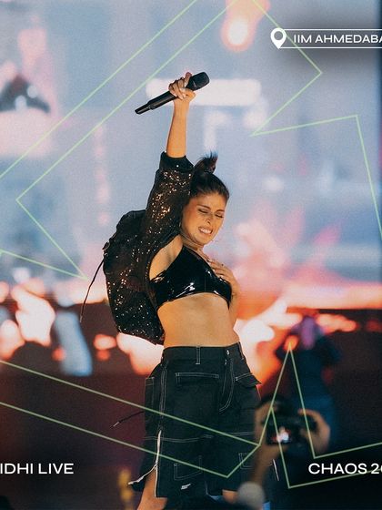 Sunidhi Chauhan in a powerful performance pose at Chaos 2024, IIM Ahmedabad.