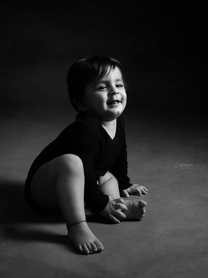 That infectious, gummy smile. This black and white portrait captures a moment of pure, unscripted joy from this adorable baby.