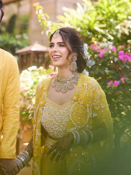 A candid, happy moment from the Haldi ceremony. Her glowing makeup and joyful smile are what we love to see.