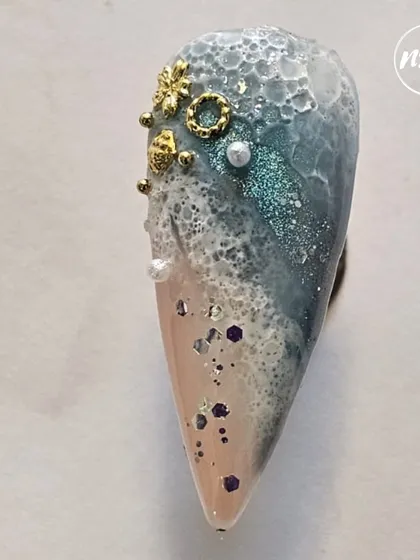 This ocean-themed nail art, with its textured foam and glittery depths, is a testament to our students' creativity. They learn to use different materials to create unique, story-telling designs like this.