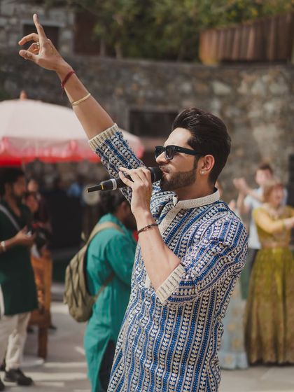 A friend of the couple hyping up the crowd during the Mehendi entry, capturing the infectious energy of the day.