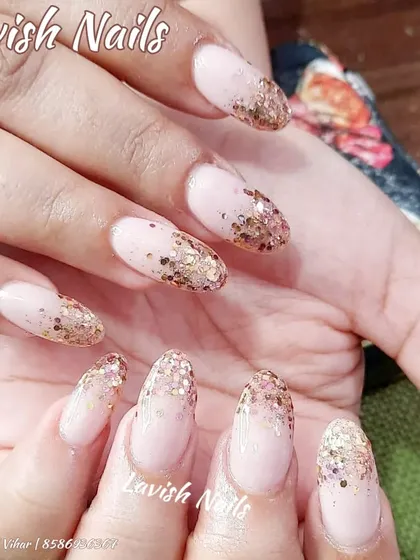 A classic gold glitter fade on almond-shaped nails with a sheer pink base.