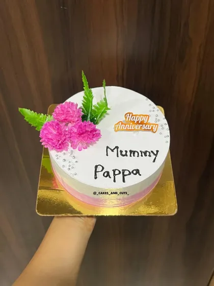A simple and sweet anniversary cake for "Mummy Pappa," with pink ombre sides and fresh pink flowers.