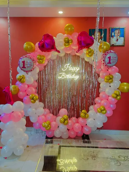 A different view of the pink and gold first birthday ring backdrop.