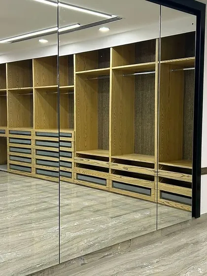 We used full-length mirrors as wardrobe doors in this walk-in closet. This not only provides a practical dressing solution but also visually doubles the size of the space, making it feel even more expansive.
