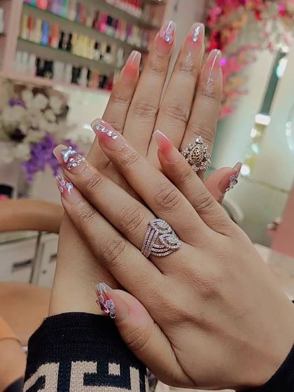 A delicate and elegant set of long, clear extensions with encapsulated glitter and subtle, artistic details.