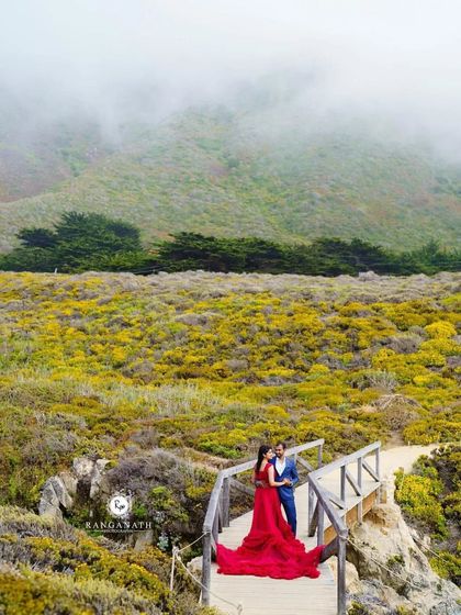 Even in the misty weather, the red gown brings warmth and vibrancy to this beautiful pre-wedding photo on a wooden bridge in a US national park.