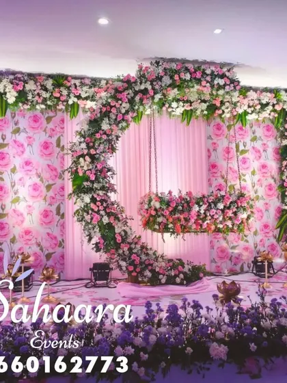 For a truly special naming ceremony or baby shower, we designed this breathtaking floral swing. The crescent moon shape, covered in soft pink and white flowers against a rose-patterned backdrop, creates a magical setting to welcome your little one.