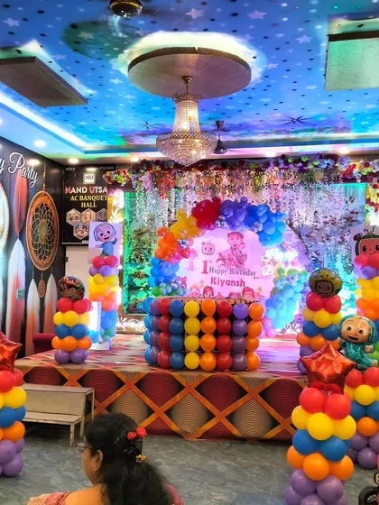 This is how I turn a banquet hall into a child's wonderland! A vibrant, large-scale Cocomelon theme for a first birthday party, complete with a multi-colored stage setup, character cutouts, and towering balloon columns.