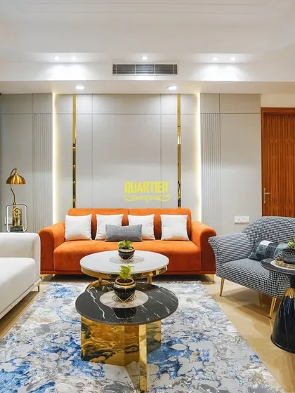 This wide shot of the Apex D'Rio living room shows how I balance bold furniture choices with a neutral wall color. The grey paneled walls with gold strips add texture and sophistication without overwhelming the space.