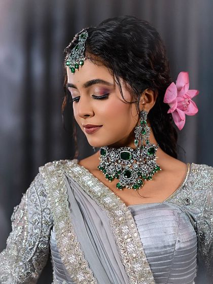 Another close-up of the grey saree look, showing the soft eye makeup and floral hair accessory.