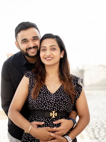 A lovely portrait from an early pregnancy announcement session. The couple's happy smiles and the way he holds her from behind create a sense of togetherness and shared joy.