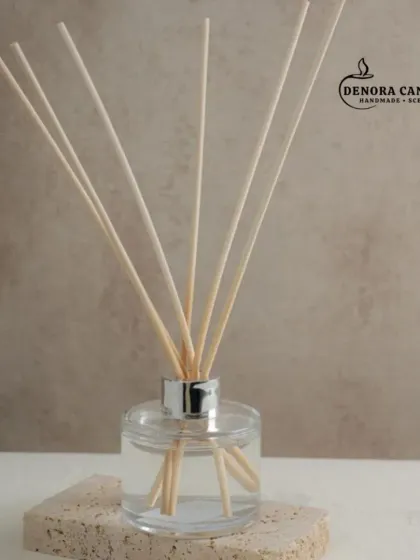 A closer look at the silver-capped reed diffuser. The clear glass bottle and natural reeds create a timeless aesthetic that complements any interior design style.