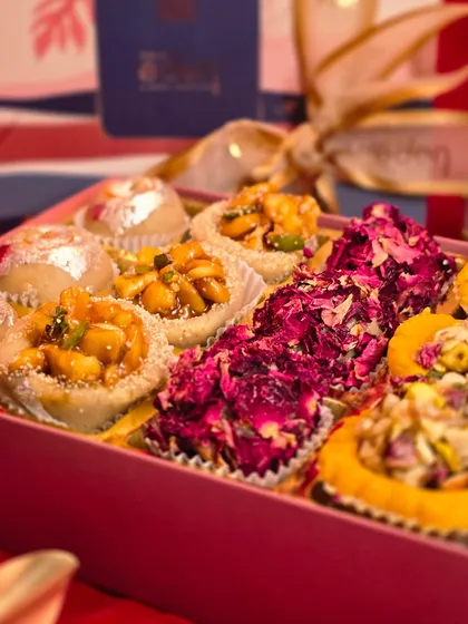 A close-up look at the artistry in my festive mithai boxes. You can see the detail of the dried rose petals, the crunch of the nuts, and the shimmer of the silver vark on each handcrafted piece.