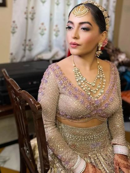 An elegant bridal portrait. The focus on her hands showcases the detailed mehendi art that completes her look.