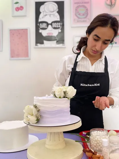 At work, adding the final floral touches to a lilac and white cake. It's these details that bring a cake to life.