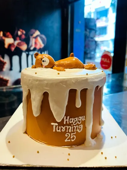 A cute and funny cake with a sleepy teddy bear melting on top, perfect for celebrating a 25th birthday with a touch of nostalgia.
