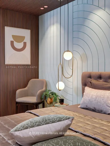 This bedroom in our Madurai project features a unique wall treatment with geometric patterns and wood fluting, complemented by modern pendant lighting for a chic, artistic look.