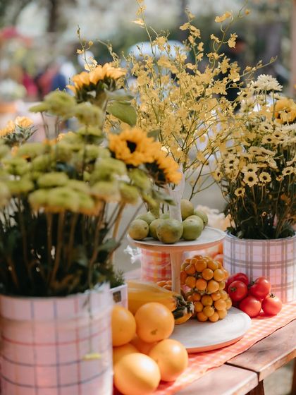 A market-style display of fresh fruits and flowers, adding to the vibrant, farm-fresh feel of the carnival Mehendi.