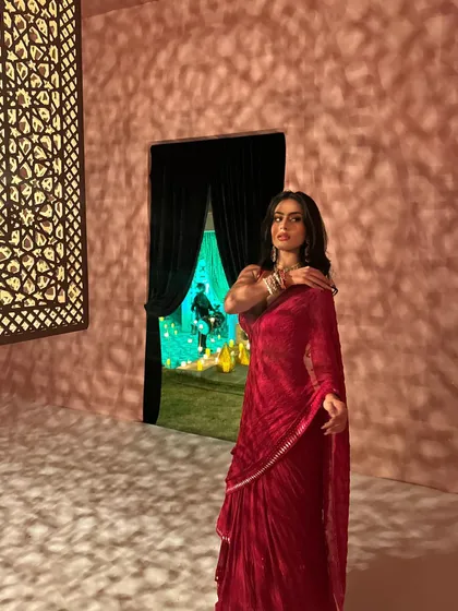 A graceful pose that showcases the elegant drape of the saree and the sparkling jewelry.