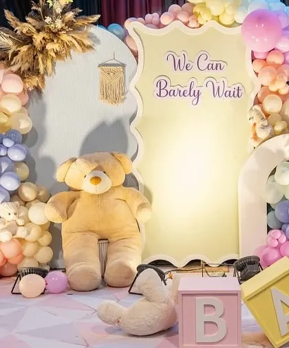 A 'beary' special baby shower in dreamy pastels. This setup features a large custom backdrop, a giant cuddly teddy bear, and a rainbow of soft-colored balloons for a sweet and gentle celebration.