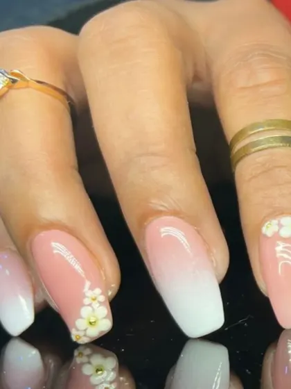 A close-up of the 3D floral accents on the baby boomer ombre nails.