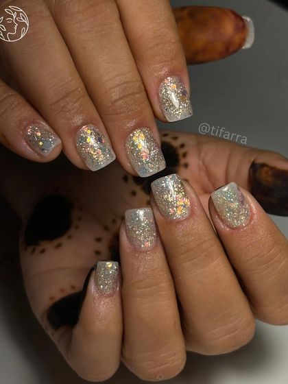 A full view of the dazzling holographic glitter nails, shown against a hand with henna.