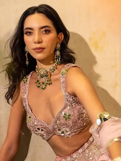A close-up on a beautiful emerald and polki set from Virok by Tatiwalas, paired with a pastel pink mirror-work lehenga. The right jewellery can elevate any outfit.