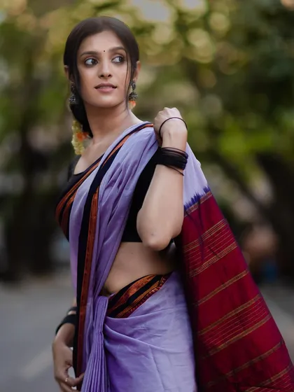 A side profile showing the beautiful fall of the Ilkal saree's pallu. The rich red and gold stripes are a hallmark of this traditional Karnataka weave.