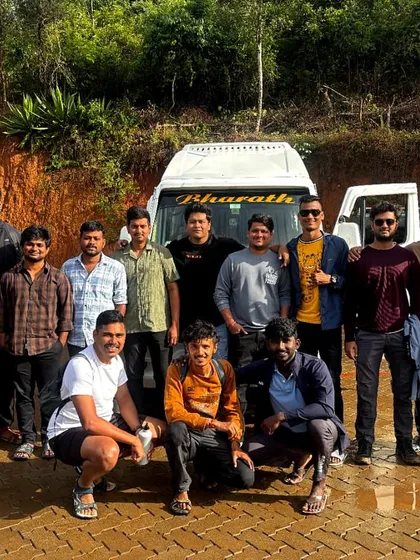 A large group of trekkers posing in front of their transport van. We handle all the logistics, so you can focus on making friends and enjoying the journey.