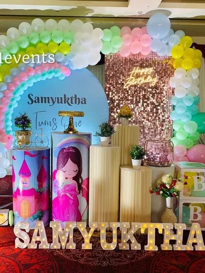I love bringing colorful ideas to life, like this rainbow and princess combination for a first birthday. It features a pastel rainbow balloon arch, a sequin backdrop, a light-up marquee number, and custom-themed pedestals for the cake and desserts.