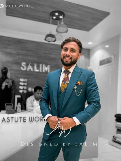 A client looking happy and confident in a custom teal three-piece suit. The patterned tie and pocket square complete this polished and personalized look.
