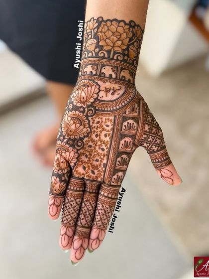 A close-up of the Indian floral design for Teej, showing the intricate details and the name written on the palm.