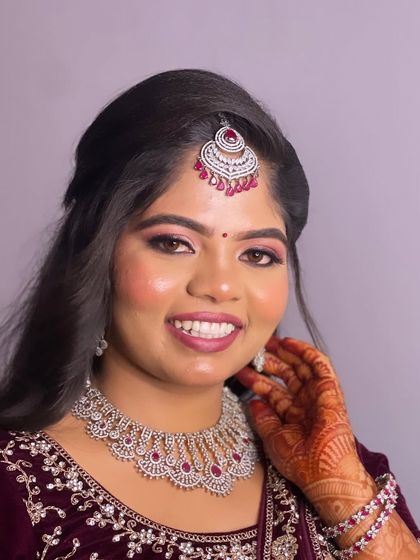 Hima looks gorgeous for her reception in a deep velvet lehenga. I paired her outfit with a sparkling diamond and ruby jewellery set and created a makeup look with pink shimmery eyes and a matching lip.