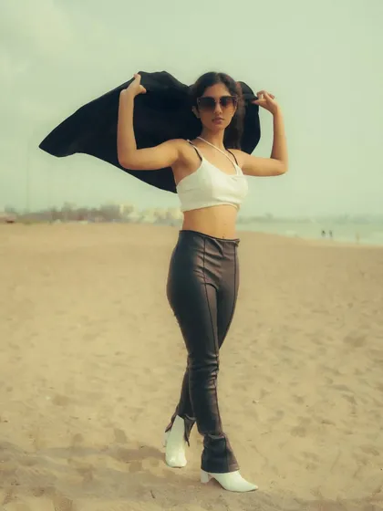 Using a black jacket as a prop to create dynamic shapes against the sky. This beach portrait is a great example of how to add movement and interest to a fashion shot.