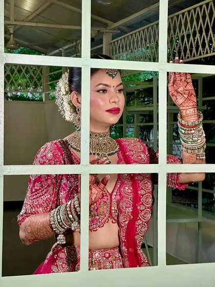 This is one of my favorite shots. It captures that quiet moment of anticipation before a bride steps out for her pheras. The makeup is designed to look flawless both up close and from a distance.