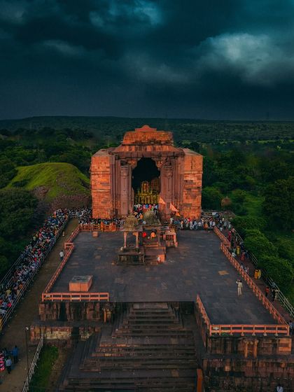 An aerial view of the unfinished Bhojpur Temple against a dramatic, cloudy sky. The temple stands as a testament to the faith and ambition of Raja Bhoj.
