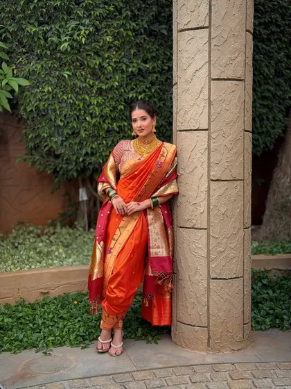 A full-length view of the meticulously draped Navari saree. The makeup is kept fresh and radiant to balance the richness of the traditional attire and heavy gold jewellery.