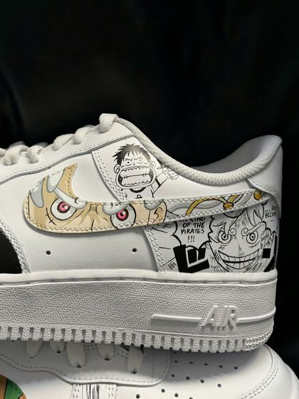 A close-up on the custom One Piece manga panel sneaker, showing Luffy in Gear Fourth Snakeman form integrated into the Nike swoosh.