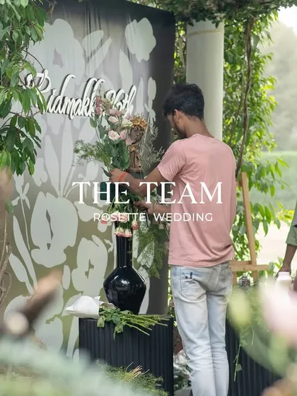 A team member adding the final floral touches to a custom-designed backdrop. Every detail is carefully considered and executed.
