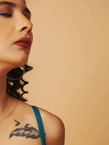 A serene, artistic beauty portrait focusing on the model's profile and a hint of her shoulder tattoo.